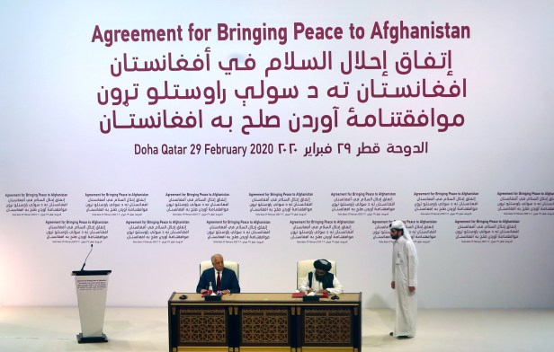 Mullah Abdul Ghani Baradar, the leader of the Taliban delegation, signs an agreement with Zalmay Khalilzad, U.S. envoy for peace in Afghanistan, at a signing ceremony between members of Afghanistan's Taliban and the U.S. in Doha